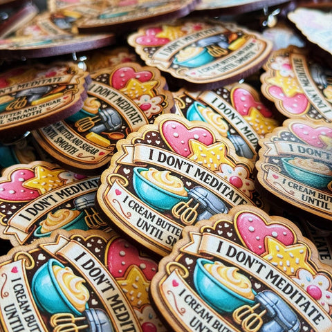 Colorful enamel pins with humorous text and graphics on a dark background
